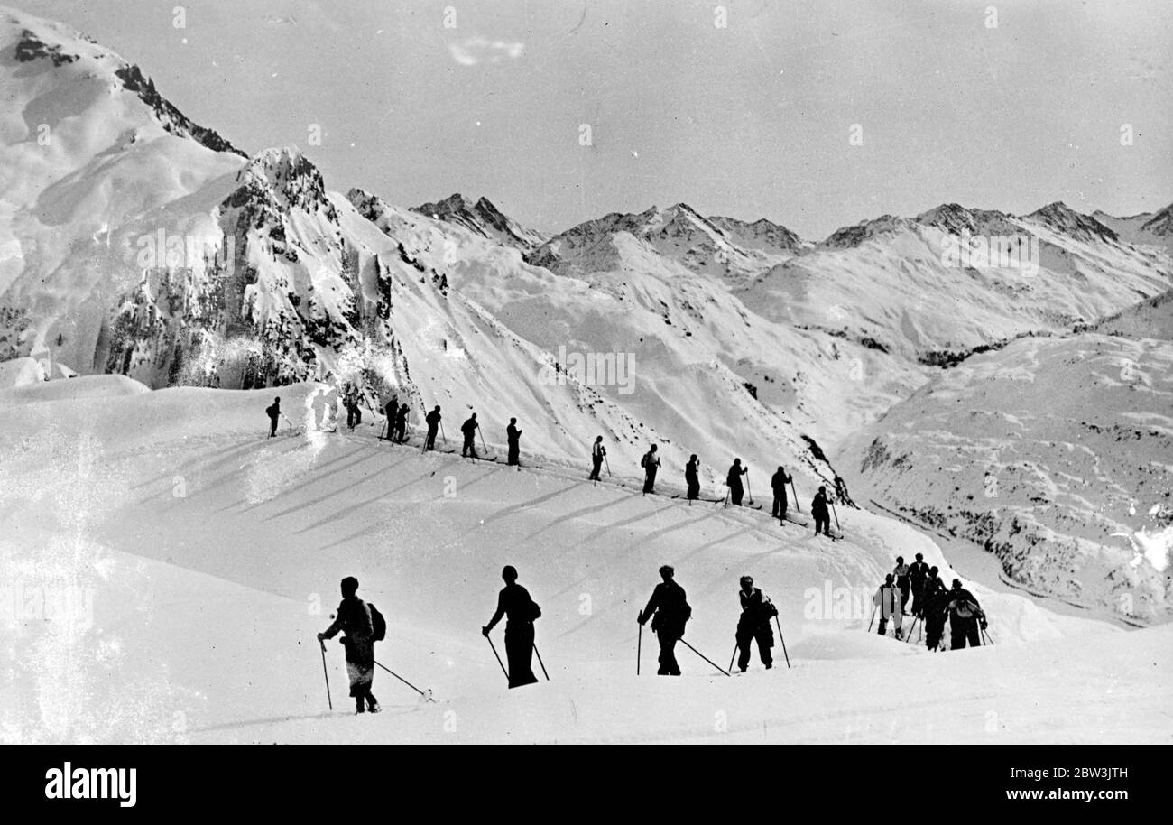 In a world of black and white . Skiers trekking through the snow covered heights of Zurs in the majestic Arlberg mountains of Austria . 4 December 1935 Stock Photo