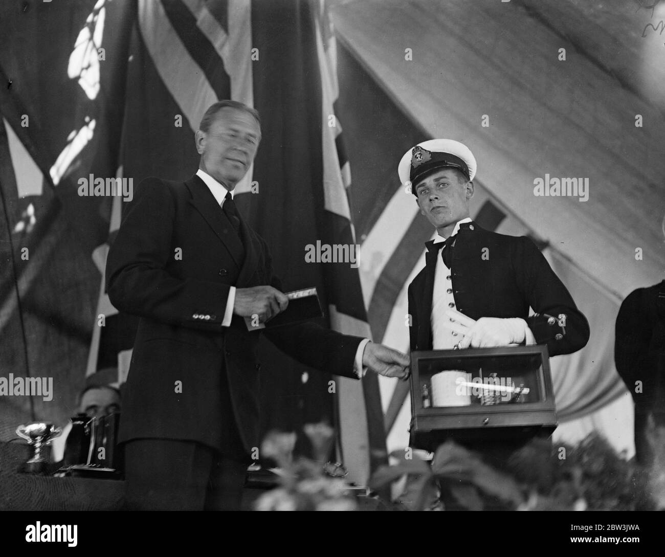 Prize Day on the HMS Worcester , the training ship of the Thames Nautical Training College in Greenhithe , Kent .Photo shows , Sir Bolton Eyres Monsell , First Lord of the Admiralty presenting to R A N Cox , who took the King ' s Gold Medal , one of his many prizes . 2 August 1935 Stock Photo