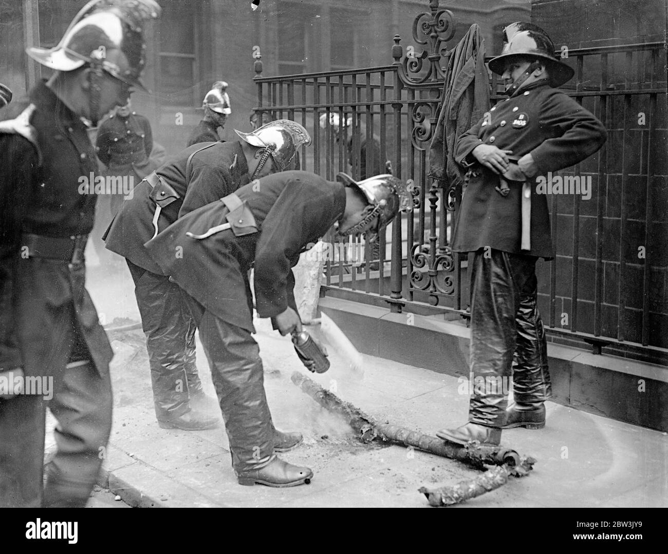 Explosions and fire follow fusing of cable near law courts . A series of explosions and fire followed the fusing of a cable in Portugal Street , near the Law Courts . Manholes were blown up and the gas mains were also affected . Three fire engines were called . Photo shows , firemen extinguishing the burninig cable . 7 May 1936 Stock Photo