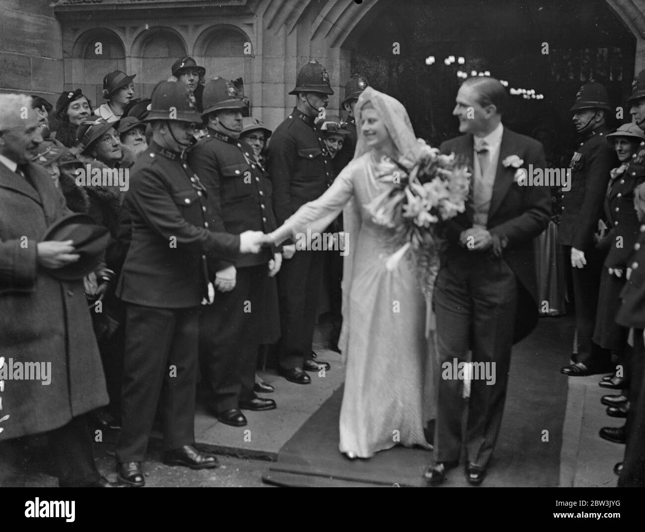 Daughter of Sir Lionel Faudel Phillips weds son of Sir Berkeley Sheffield at Hertford . The wedding of Miss Anne Faudel Phillips , to Mr John Sheffield , son of Sir Berkeley and Lady Sheffield took place at All Saints Church , Hertford . Photo shows , the bride shaking hands with police guard of honour as she left the church with the bridegroom . 21 April 1936 Stock Photo