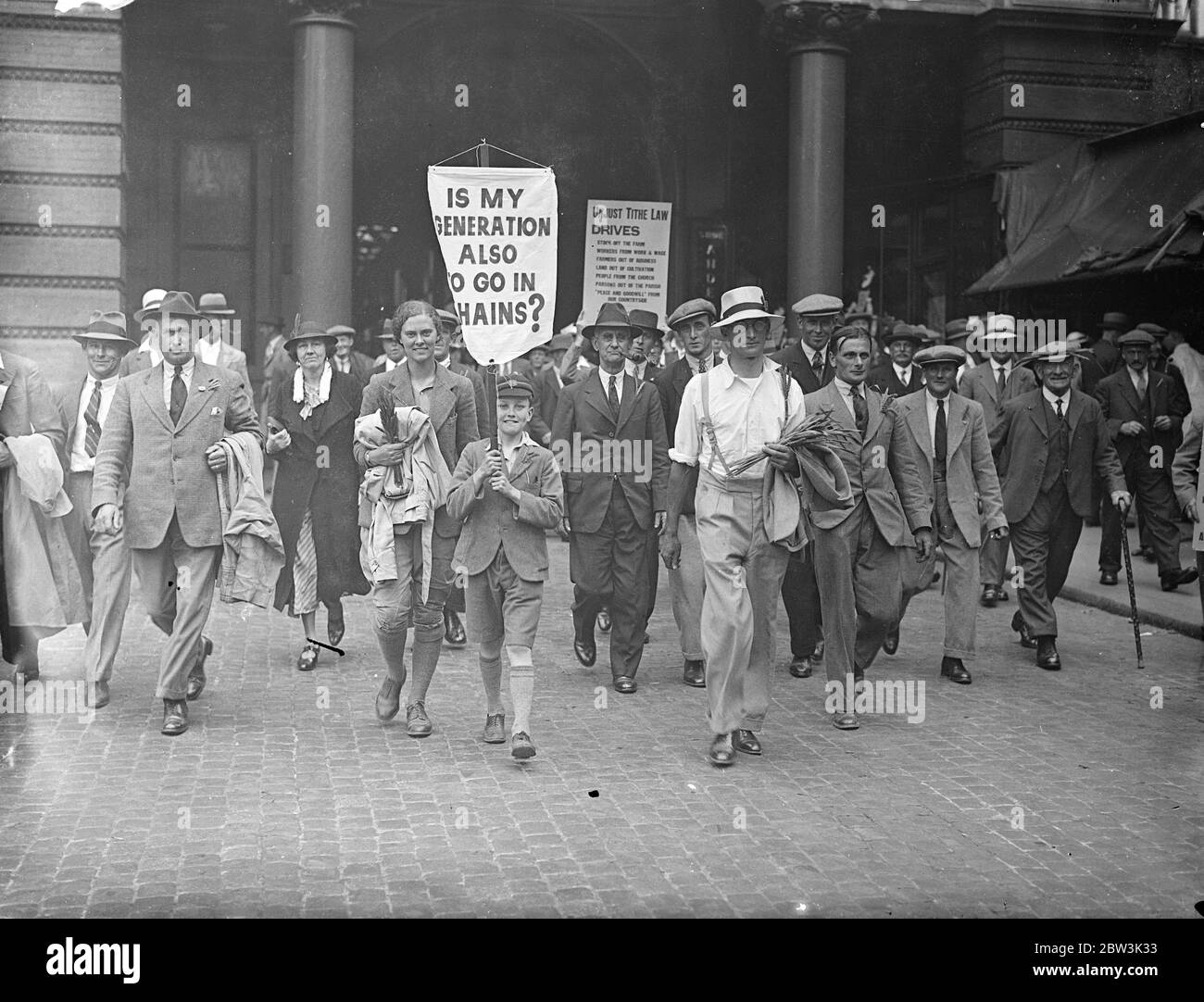 Kent Tithe - Payers Arrive To Join Huge Demonstration Against Tithe Bill Leaving their fields in the hight of the important haymaking season , 5 , 000 farmers and workers from many of the English counties , arrived at Charing Cross Station to march to Hyde Park for a gigantic demonstrations against the Tithe Bill . Sixteen special trains , coaches and even farm carts have been use to bring the demonstrators to London . Following the Hyde Park meeting a deputation to wait upon the Premier at the House to demand the withdrowal of the Bill . Photo Shows : Kent tithepayers marching from Charing Cr Stock Photo