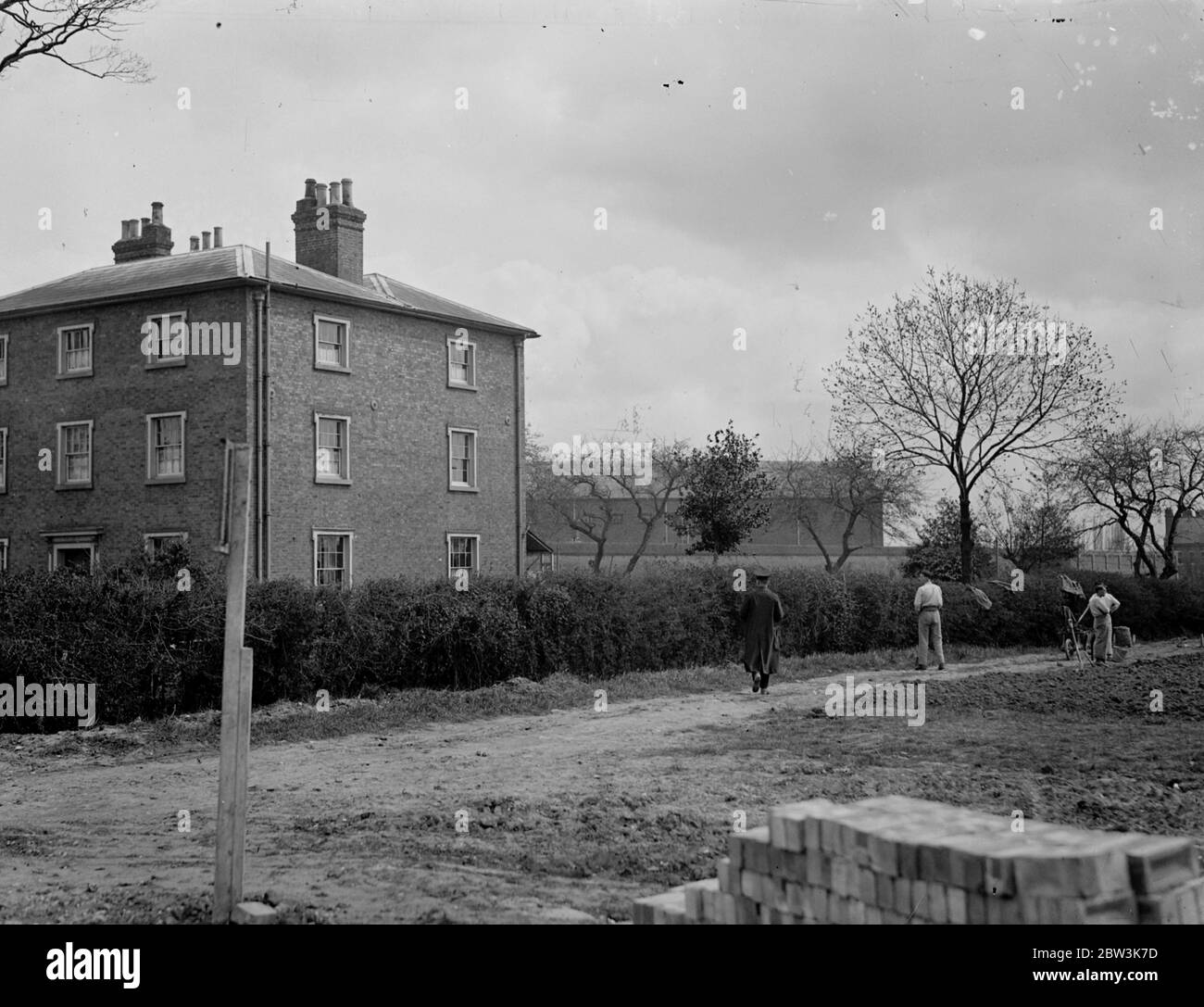 Convicts build houses in view of open road at Chelmsford . Seperated from the stream of terrif on the busy Sandford Road at Chelmsford , Essex , only by a prison patrol , a number of prisoners from Chelmsford Prison are building new homes for their warders . The men , most of whom are highly skilled , are carrying out the work under a plan known to the Prison Commissioners as the Chelmsford Experiment , designed to keep young prisonersaway from the ' old hands ' and to put them on to responsible work . It is hoped that the scheme will enable them to take their place once more in public life . Stock Photo