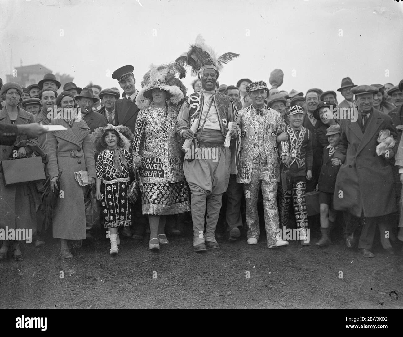 Monolulu and Pearlies on the Derby course . Photo shows , Prince Monolulu , famous tipster , with Pearlies on the Derby course at Epsom . 27 May 1936 Stock Photo