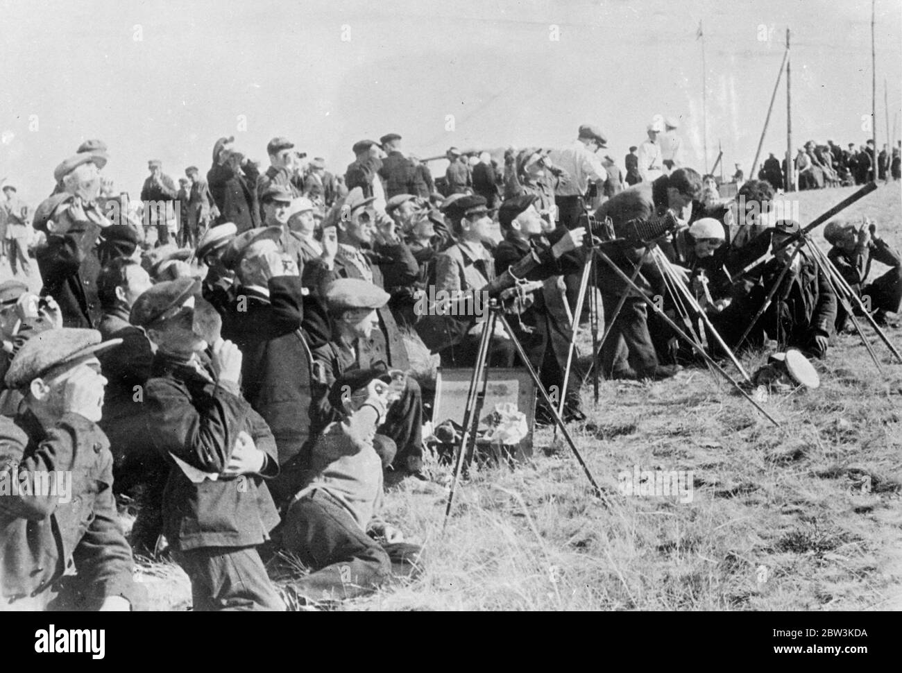 Amateur Astronomers Observe Solar Eclipse At Ak - Bulak Working almost side by side with scientists from Harvard University ( USA ) and Pulkovo Observatory ( Leningrad ) hundreds of amateur astronomers had a perfect view of the total eclipse of the sun from Ak - Bulak on the Kazakhstan border USSR . Photo shows: Amateurs observing the eclipse with telescopes , cameras and smoked glass at Ak - Bulak 22 Jun 1936 Stock Photo