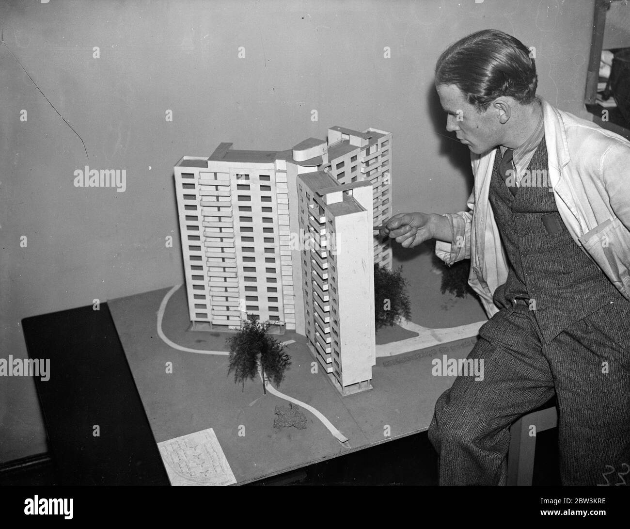 Fifteen storey tenements to be built . Fifteen storey buildings proposed to replace slums in centre of London . A model of the fifteen storey flats for slum clearance in St Pancras designed by four students of the Architectural Association School . Mr B A Le Mare , one of the students , is standing with the model . 5 January 1936 Stock Photo