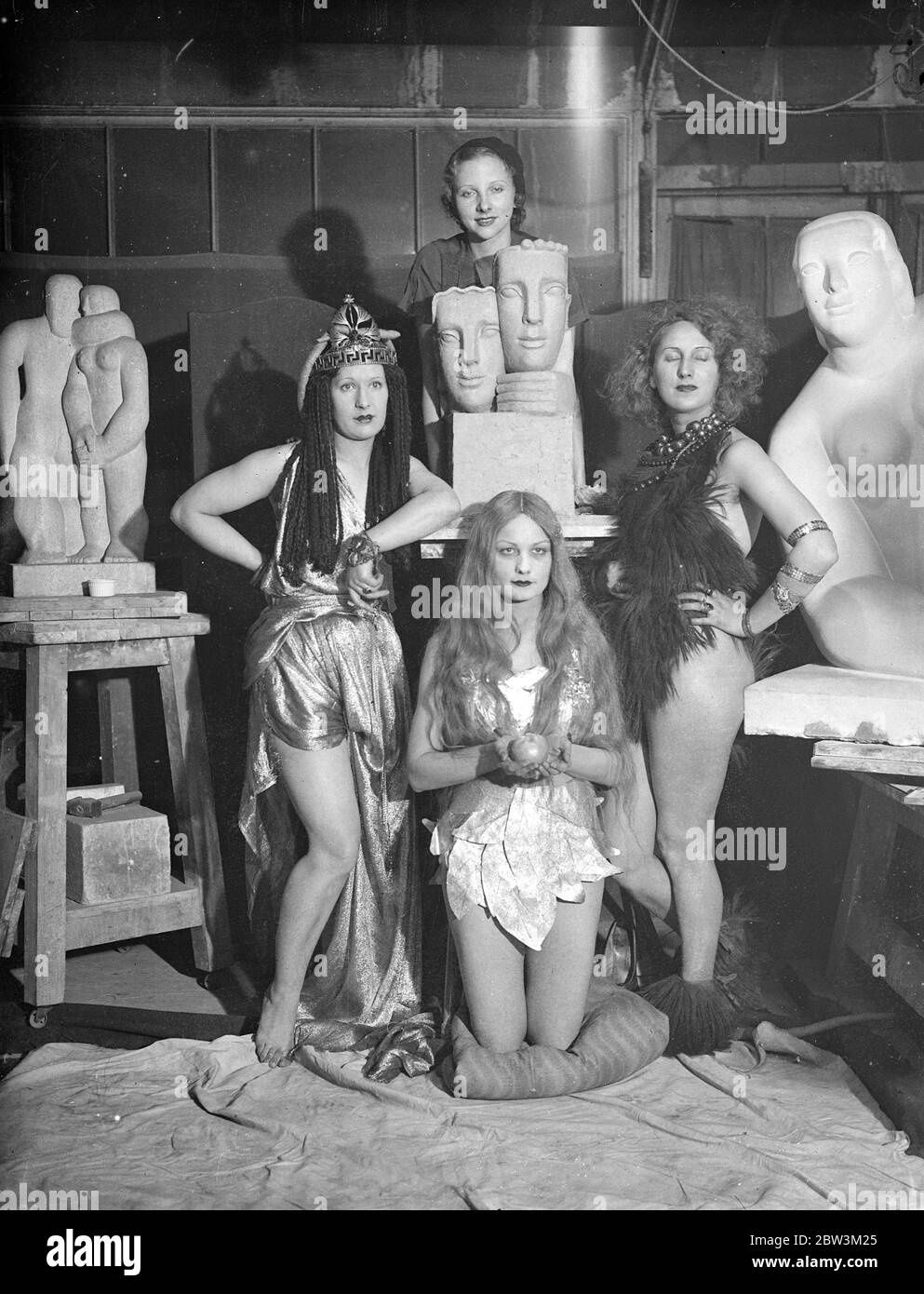 Into the past , for Chelsea arts ball . Eve , clasping her fatal applex , kneels with Cleopatre and a stone age maiden before the Modern girl , during a rehearsal in Mr Frank Dobson ' s studio for the Chelsea Arts Bell , the theme of which is ' looking backwards ' . In the centre is a scale model of the huge 30 foot centre piece designed by Mr Frank Dobson for the Ball . 23 November 1935 Stock Photo