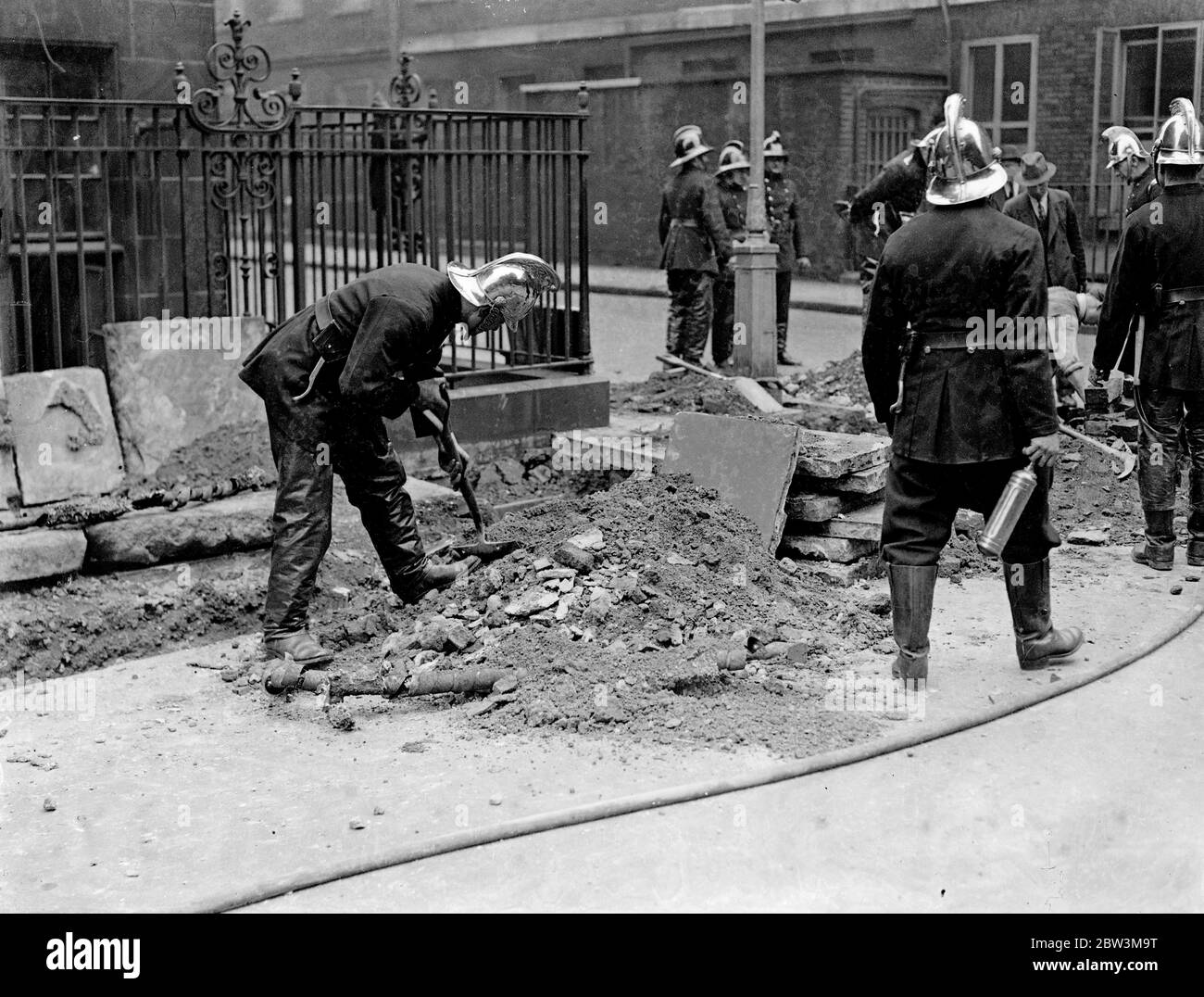 Explosions and fire follow fusing of cable near law courts . A series of explosions and fire followed the fusing of a cable in Portugal Street , near the Law Courts . Manholes were blown up and the gas mains were also affected . Three fire engines were called . Photo shows , firemen extinguishing the burninig cable . 7 May 1936 Stock Photo