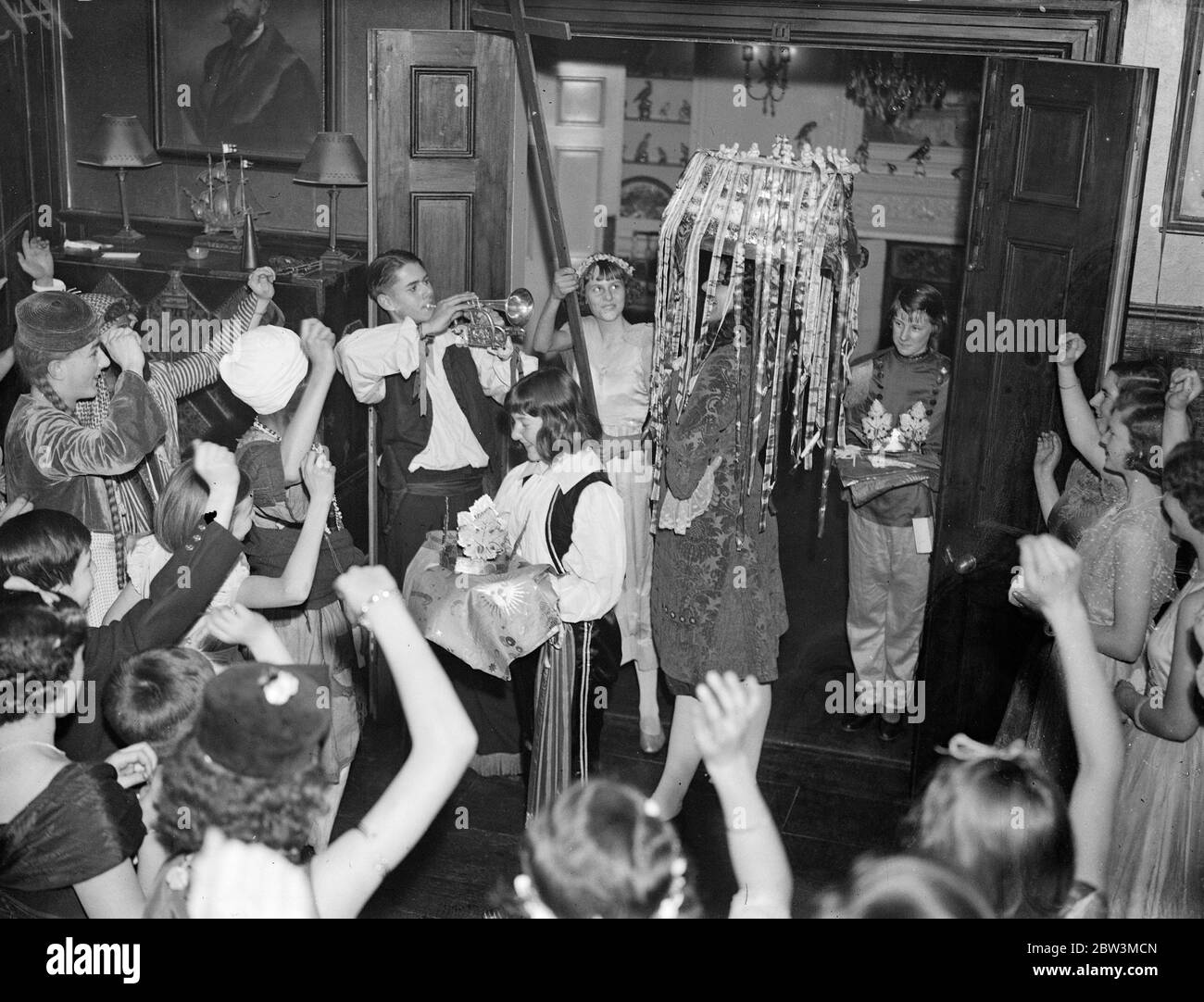 Cheering in the cake at children 's twelfth night party at Tite Street , London . 6 January 1936 Stock Photo