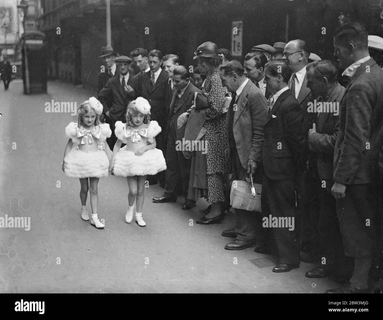 Twin  Powder Puffs  At London Hippodrome Children ' s Matinee . Children provided the entertainment at the annual London Hippodrome matinee in aid of the Queen ' s Hospital for Children , Bethnal Green . The children who took part ranged from two to seven years of age , and a  Modern Picture  showed small babies dressed as their mothers and fathers . Photo shows : Anne and Mary Holman , twin sisters , arriving in their powder puff costumes watched by a crowd . 7 Jul 1936 Stock Photo