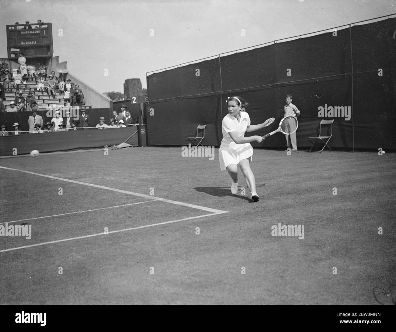 Helen Jacobs Defeats Mrs . Cable In Wimbledon Championships . Miss Helen Jacobs ( USA ) defeated Mrs . Cable of Great Britain 6 - 1 , 6 - 0 in the first round of the women ' s singles in the Wimbledon Tennis Championships Photo Shows : Mrs . Cable in play against Helen Jacobs . 23 Jun 1936 Stock Photo