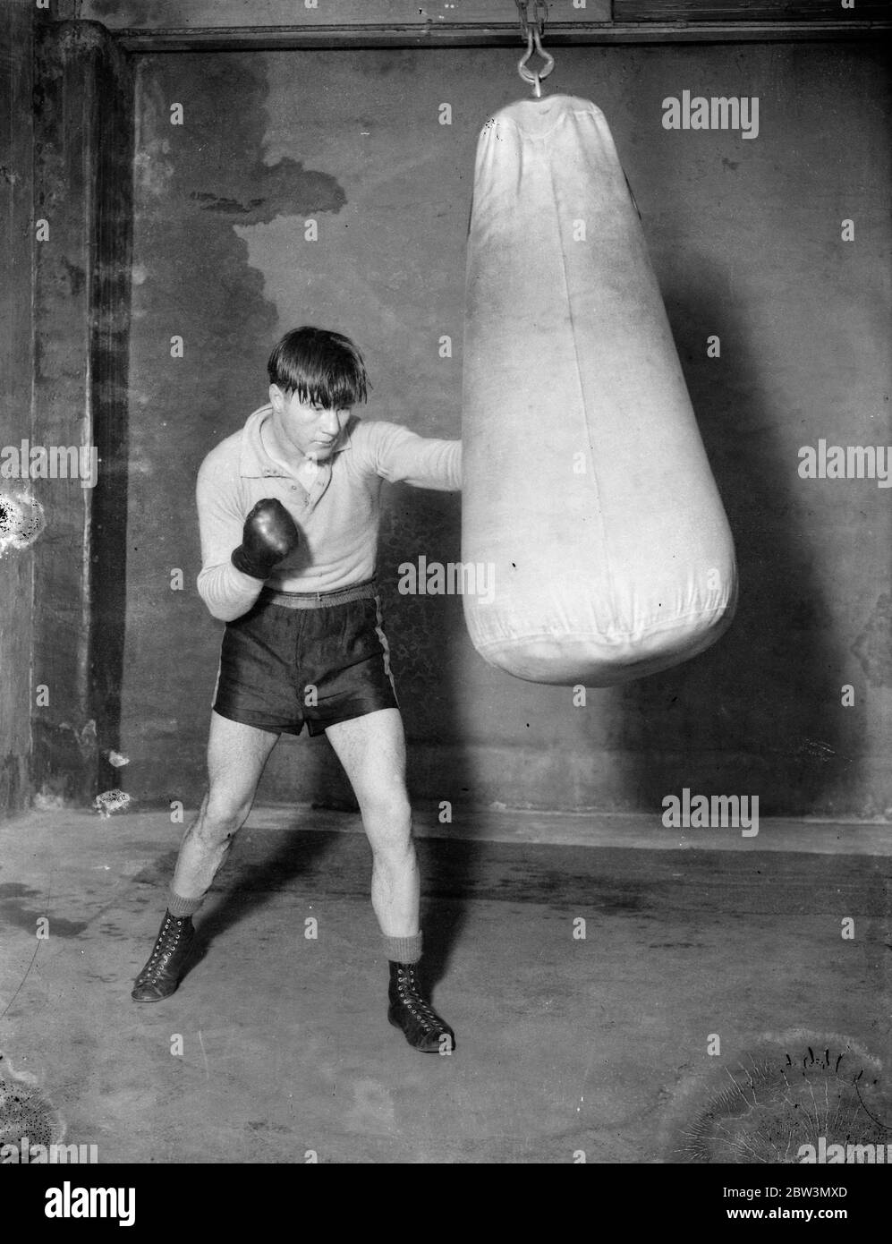 Daly puts punch into it . Training for match with Humsby . George Daly , the Blackfrisrs light weight is training at the Ring gymnasium Blackfriars , for his ten round match with Gustave Humery , the French Tiger and conqueror of Kid Berg . Daly , winner of the Control Board ' s series of light weight eliminators but ruled out ruled out because of his revolt against purse conditions , is hoping to prove that he is the rightful contender for Berg ' s British Championship . Photo shows , George Daly punching a bag during training at the Ring gymnasium . 10 January 1936 Stock Photo