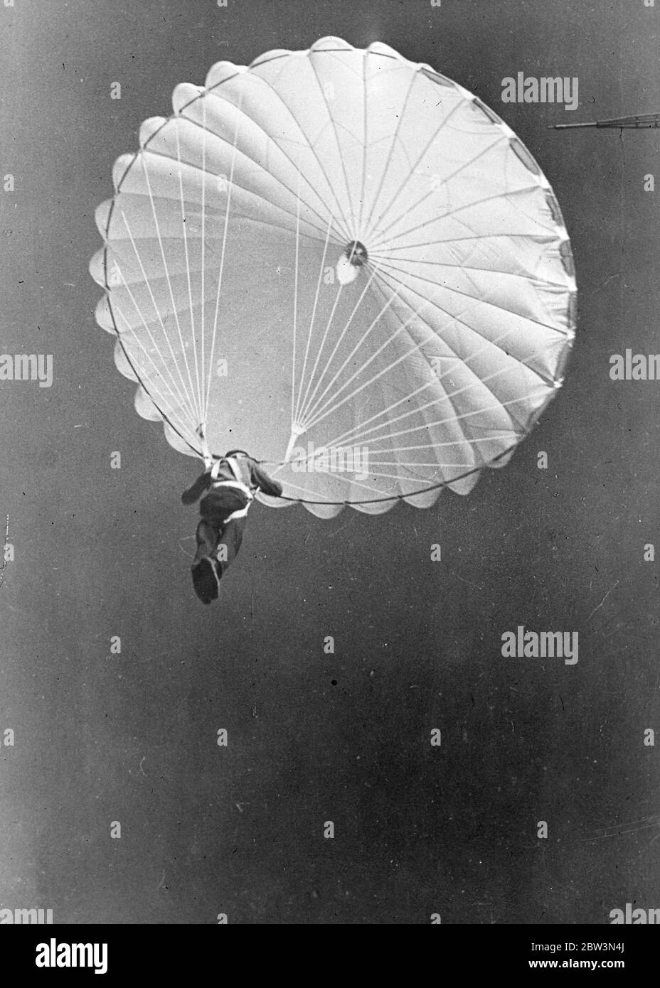 He 's certain of a happy landing . With all the ponchalance of a hard bitten daredevil , a young worker of the Novotula Metallurgical Plant at Tula , nearly 200 miles from Moscow , floats to earth by parachute - master of 135 feet of space . Novice parachutists are trained from a special tower , 135 feet high , the arm of which can be seen top right . The parachute is already opened . The parachute tower was built by the factory workers themselves together with an aerodrome . They have organised their own flying school . 10 December 1935 Stock Photo