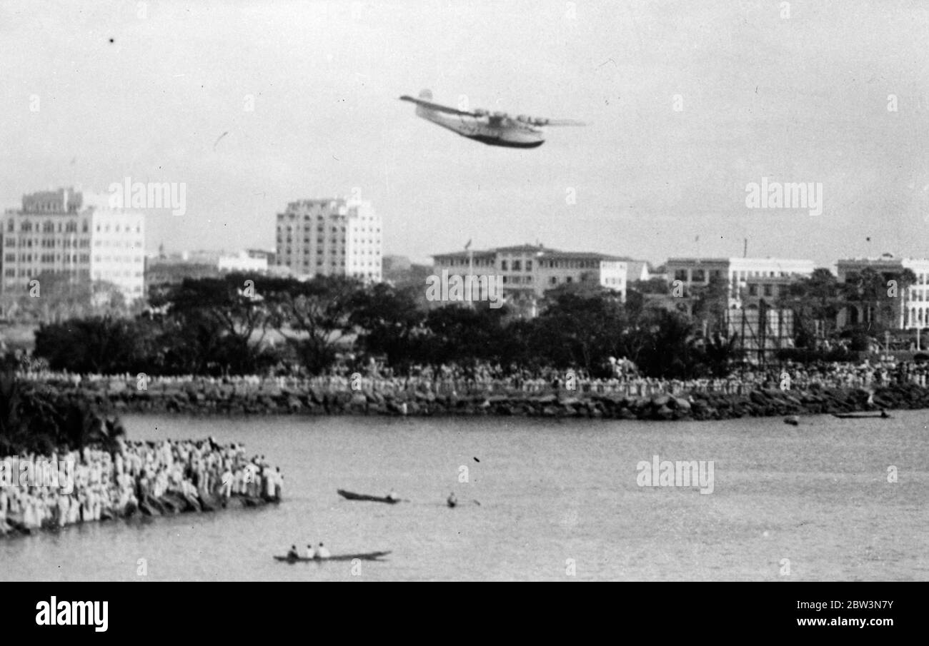 China clipper , arrives at Manilla after first trans pacfic air mail flight . With battleships of the American Asiatic fleet in gala dream for the occasion , the giant United States seaplane ' China Clipper ' glided onto the water in Manilla Harbour after having completed the first trans Pacific air mail flight . The journey from San Fancisco Bay , California , to the Philippines , took a week . Photo shows , the ' China Clipper ' descending onto the water on arrival at Manilla . The shore can be seen packed with people to welcome her . In the background , left to right are the University Apar Stock Photo