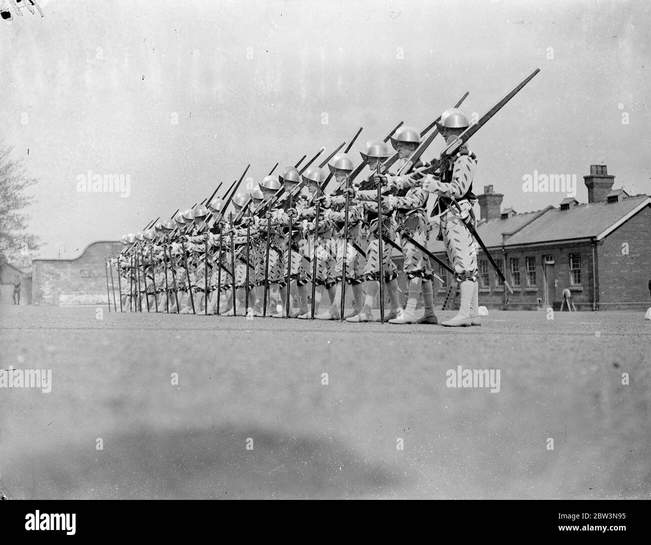 Norfolk regiment ' Musketeers ' rehearse for Royal Tournament . The 2nd Battalion , the Royal Norfolk Regiment , held a full rehearsal at Aldershot for the pageant which will be a feature of the Royal Tournament at Olympia . Photo shows , ' Musketeers ' of the Elizabethan period drilling . 30 April 1936 . Stock Photo