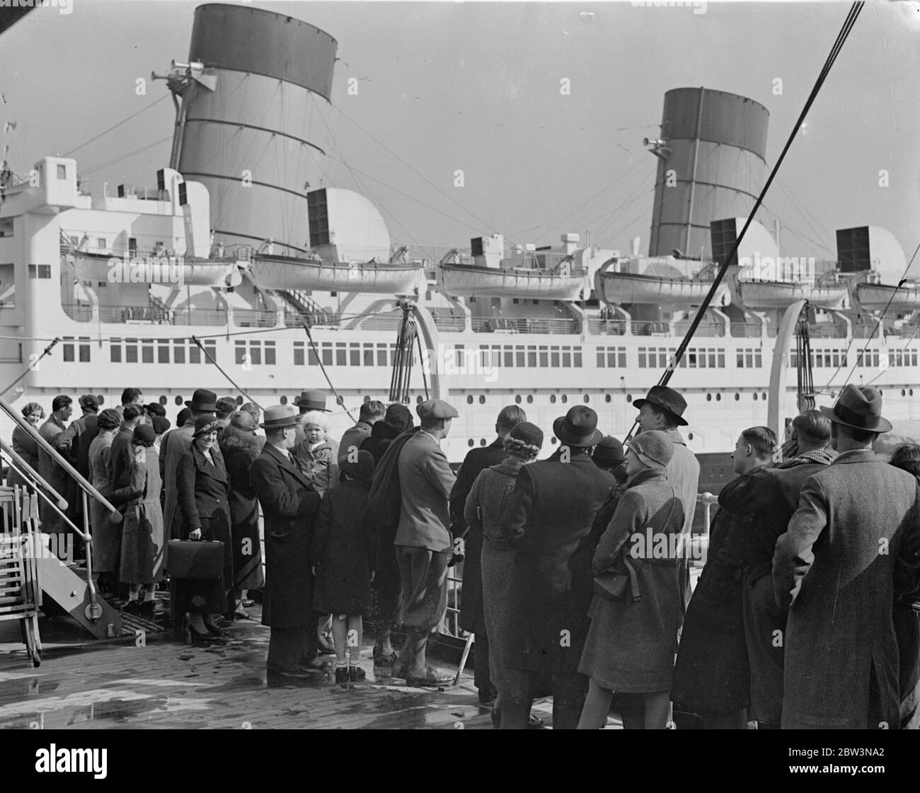 Queen Mary as Easter attraction . Thousands of Easter holidaymakers crowded pleasur steamers at Southampton in order to obtain a close up view of the ' Queen Mary ' as she lies in the Ocean Dock . Photo shows , viewing the ' Queen Mary ' from a pleaure steamer at Southampton . 13 April 1936 Stock Photo