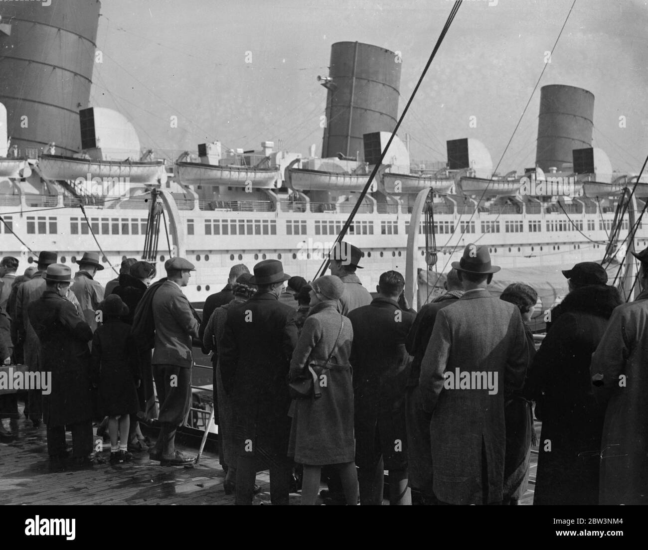 Queen Mary as Easter attraction . Thousands of Easter holidaymakers crowded pleasur steamers at Southampton in order to obtain a close up view of the ' Queen Mary ' as she lies in the Ocean Dock . Photo shows , viewing the ' Queen Mary ' from a pleaure steamer at Southampton . 13 April 1936 Stock Photo