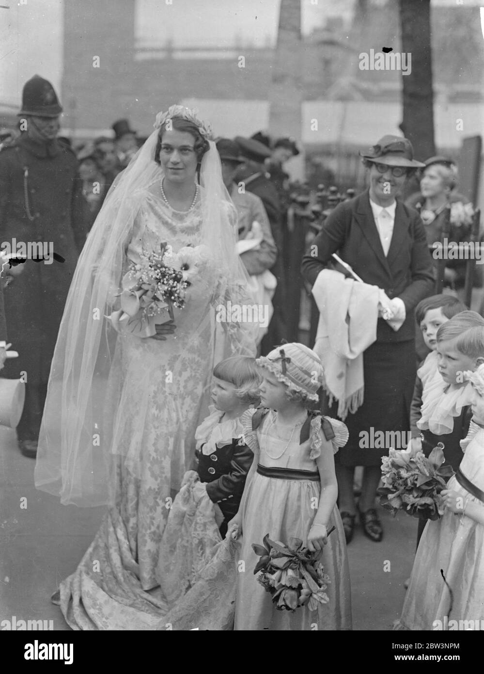 Tiny bridal attending at St Margaret ' s wedding . Two year old John Smiley , son of Sir Hugh and Lady Smiley , acted as page for the first time when wedding took place at St Margaret ' s Church , Westminster , of Miss Elizabeth Kerr Smiley and Mr Christopher Hussey . Lord Monsell , First Lord of the Admiralty and Lady monsell , lent Admiralty House for the reception . Photo shows the bride with john Smiley and another tiny bridal attendant . 23 April 1936 Stock Photo