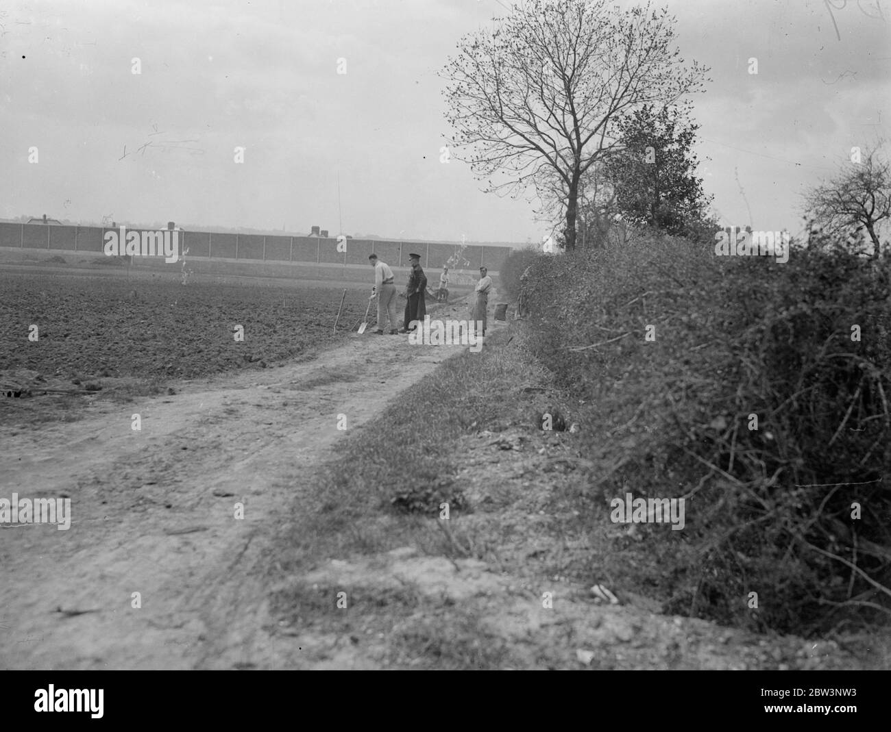 Convicts build houses in view of open road at Chelmsford . Seperated from the stream of terrif on the busy Sandford Road at Chelmsford , Essex , only by a prison patrol , a number of prisoners from Chelmsford Prison are building new homes for their warders . The men , most of whom are highly skilled , are carrying out the work under a plan known to the Prison Commissioners as the Chelmsford Experiment , designed to keep young prisonersaway from the ' old hands ' and to put them on to responsible work . It is hoped that the scheme will enable them to take their place once more in public life . Stock Photo