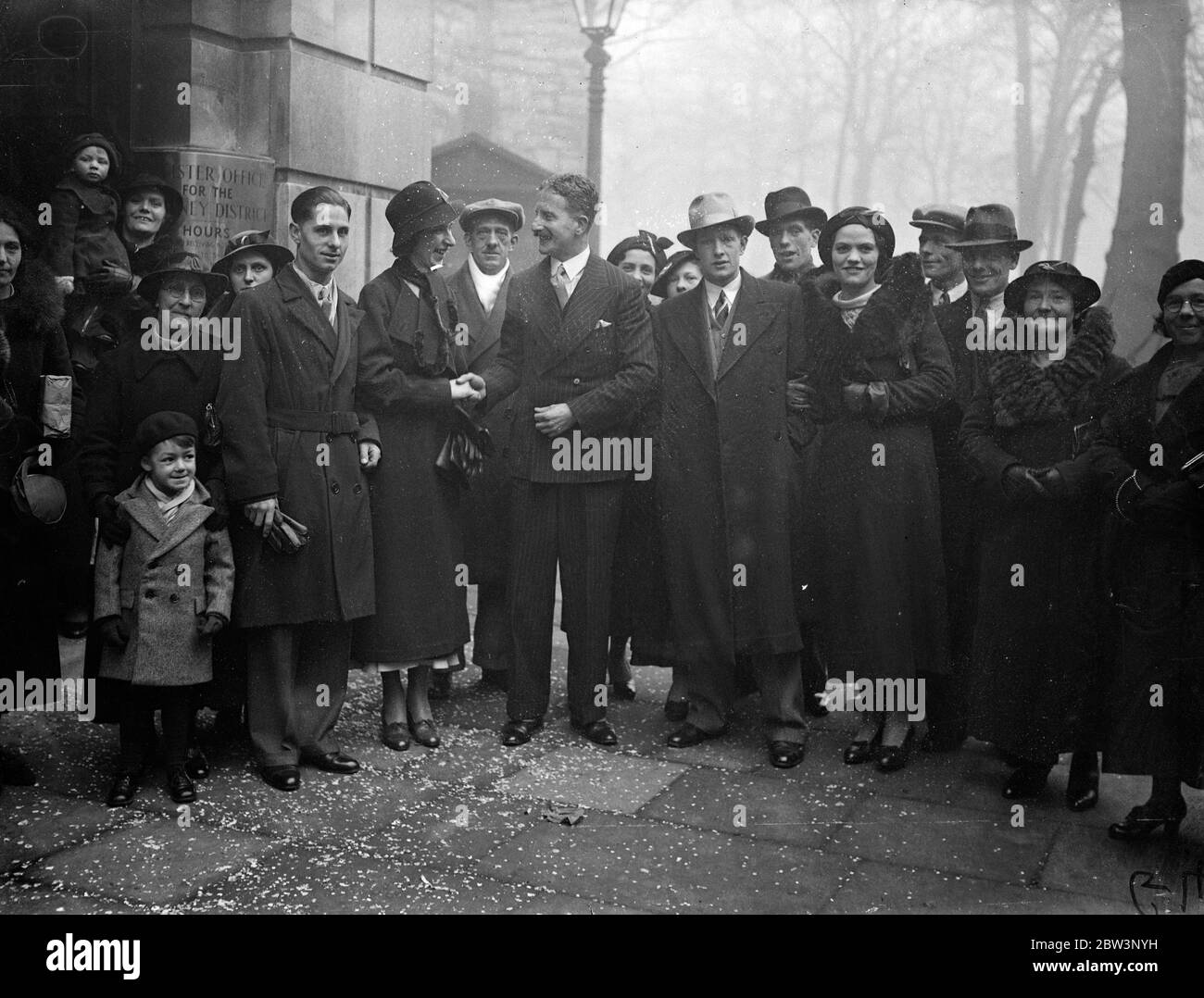 Christmas marriage records broken at Hackney as registrar performs 40 ceremonies in one day . All christmas records are being broken today ( Saturday ) at the Hackney Town Hall register office , where Mr A W Brewer , superintendent registrar , is having to perform 40 marriage ceremonies . Mr Brewer , is marrying the couples himself , and had to rise at 7 am . He has never married so many couples in one day at Christmas time before . Photo shows , Mr A W Brewer ( centre , with moustache ) congratulating some of the couples . 21 December 1935 Stock Photo