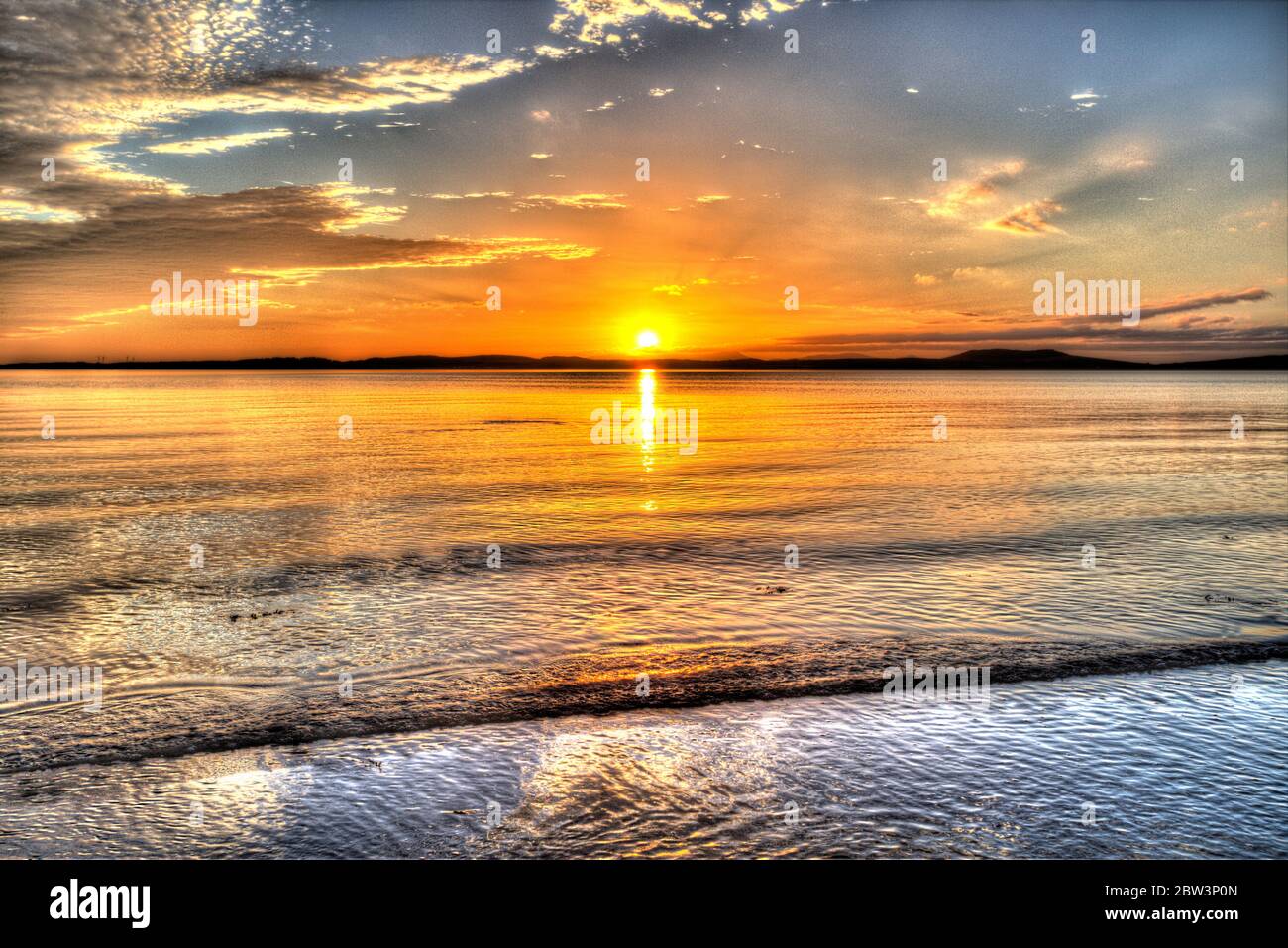 Isle of Gigha, Scotland. Artistic view of sunset over the Sound of Gigha, with the Isle of Gigha in the background. Stock Photo