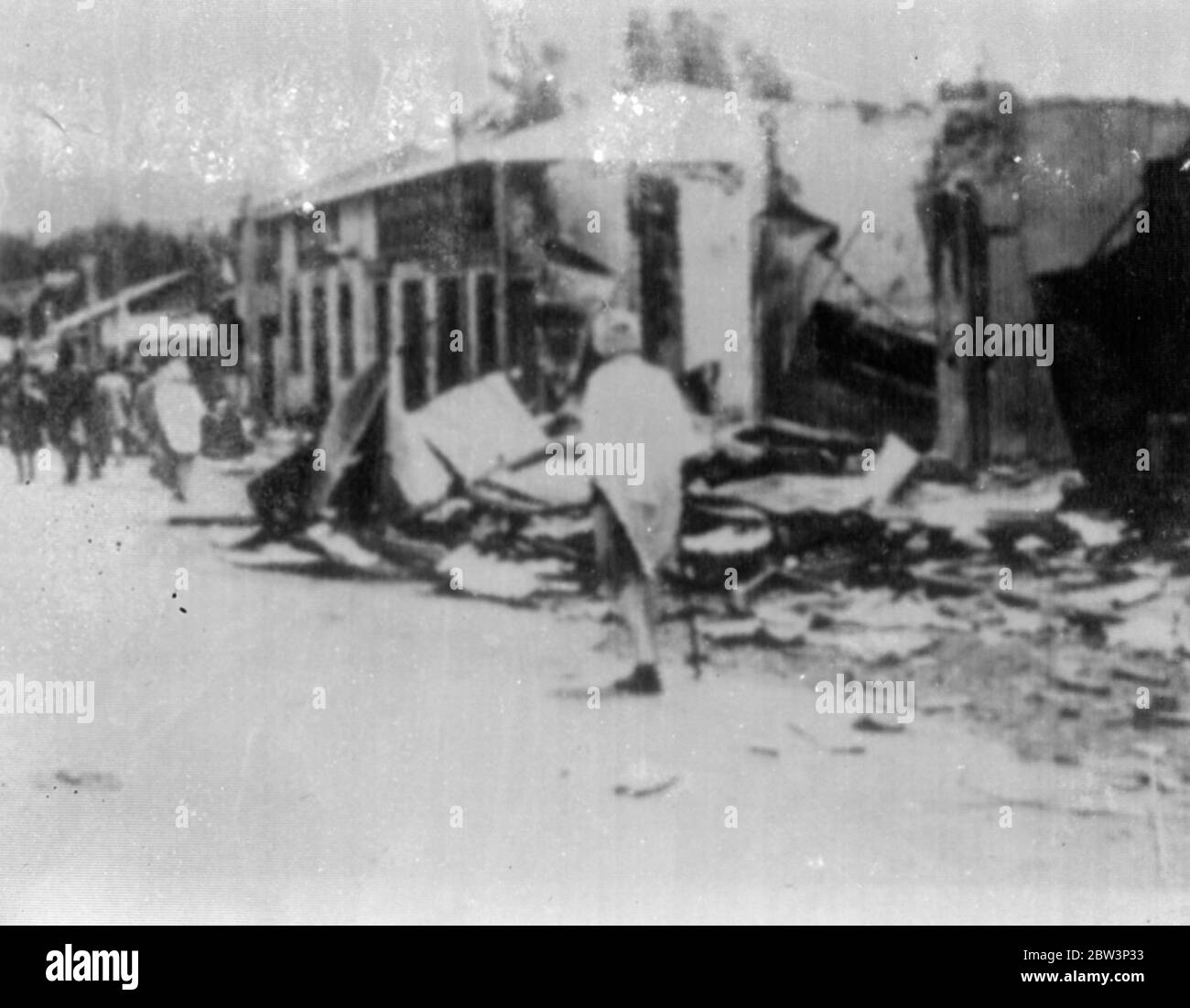 Addis Ababa in Ruins after Fire and Looting . Addis Ababa capital of Abyssinia , is now a ruined city in which the Italian troops are still working to supress looting and murder . The main part of the town was set ablase after the flight of the Emperor and the work of destruction was carried on by the Abyssinian mobs intent on pillage and slaughter . Photo shows : piles of debris in a street of ruined Addis Ababa . 15 May 1936 Photo Shows : Marshal Badoglio , Viceroy of Abyssinia , giving the Fascist salute as the Italian flag was flown over the Italian Legation in Addis Ababa . 15 May 1936 Stock Photo