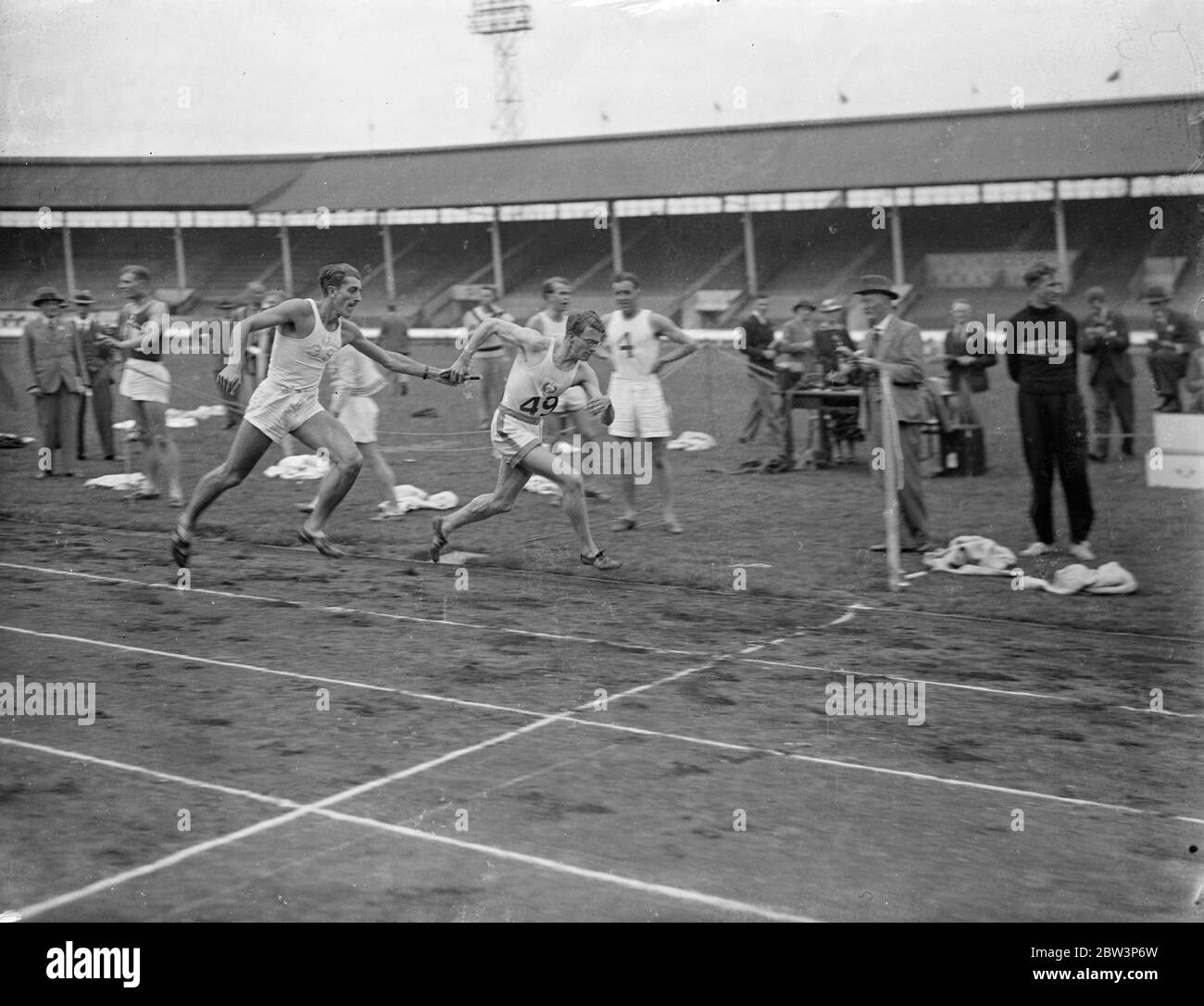 A . G . K . Brown Wins Relay Championship For Achilles At White City . The Amateur Athletic Association Junior championships meeting was held at the White City . One of the chief events was the 4 x 440 yards realy championship between London A . C . and Achilles Club . Brown won for Achilles . Photo Shows : A . G . K . Brown ( Achilles ) , the famous athlete , teking over from I . S . Ivanovic ( behind ) to win . 4 Jul 1936 Stock Photo