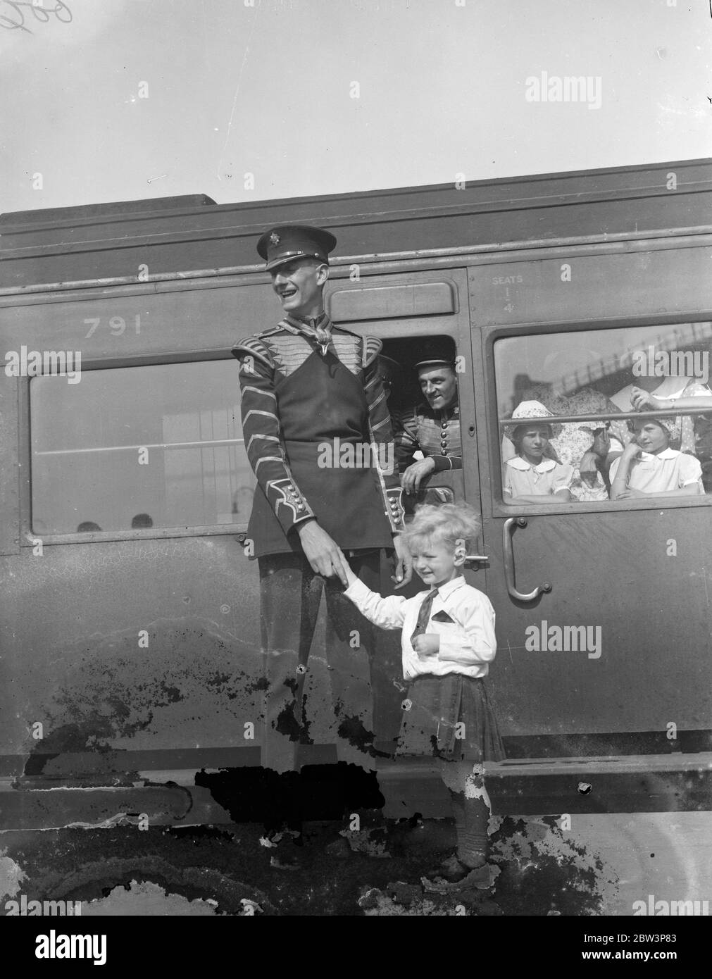 Irish Guards band leave for Canada . The Irish Guards band left Waterloo on the Ascania boat train for their Canadian tour . Photo shows , bass drummer Clarke saying goodbye to his small son Jack . 10 August 1935 Stock Photo