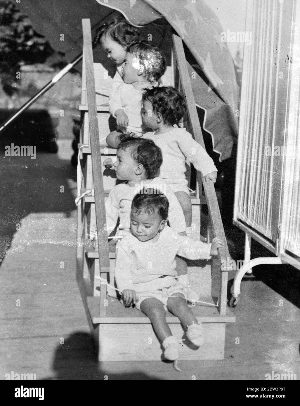 The quintuplets as perfect babies . The latest picture of the Dionne Quintuplets which shown how proper care and food have made them into perfect specimens of babyhood . The Quintuplets have now given their  support  to a fund designed to assist poor children all over America . In this picture , the Quins , carefully  roped  to their unusual perch , are imbibing the fresh air at their Callander ( Ontario ) home . From top to bottom - Yvonne , Annette , Cecile , Emilie and Marie . 22 December 1935 Stock Photo