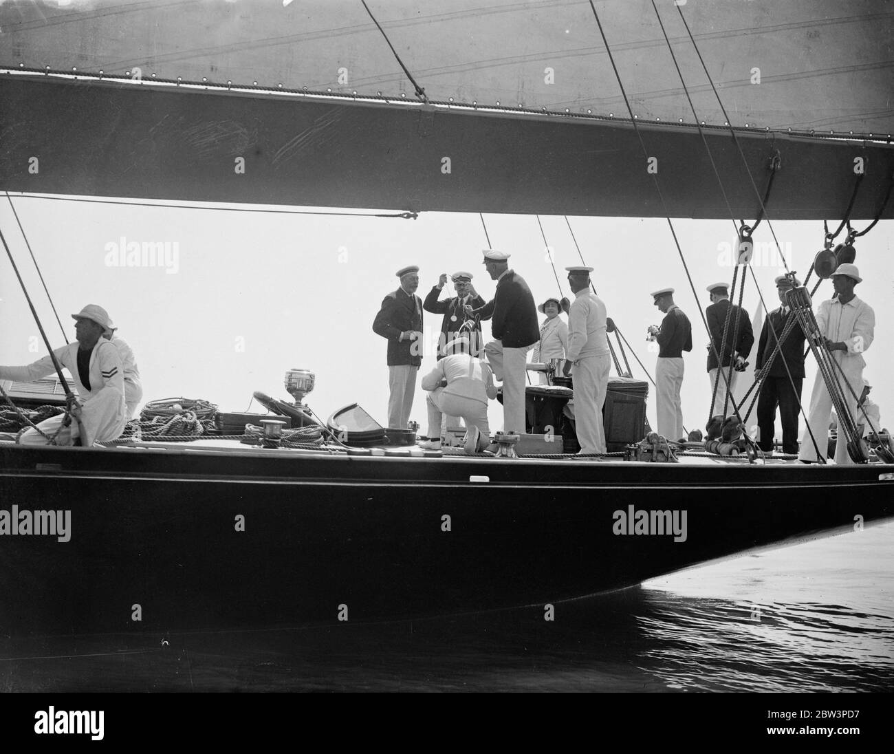 The King himself was at the helm of his half century old yacht Britannia when she competed against the American cutter Yankee and other famous big yachts in the races of the Royal Thames Yacht club of Ryde onthe Isel of Wighty . Photo shoes the Duke and Duchess of York aboard Britannia during the racing . 31 July 1935 Stock Photo