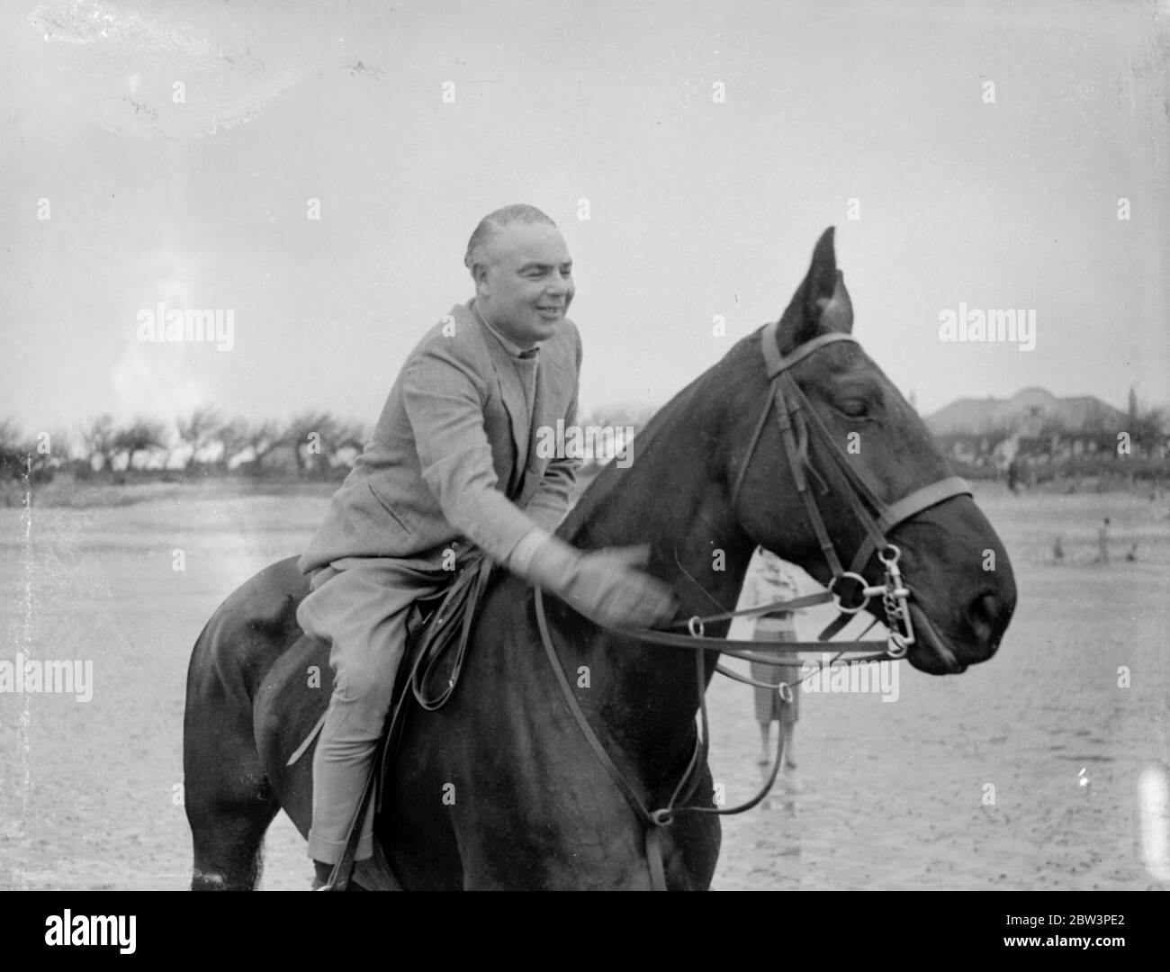 Mr Hore Belisha spends his holiday - on horseback . Away from transport problems . Mr Hore Belisha pats his horse after a fast gallop on the sands at Ferring-by-sea . 15 April 1936 Stock Photo