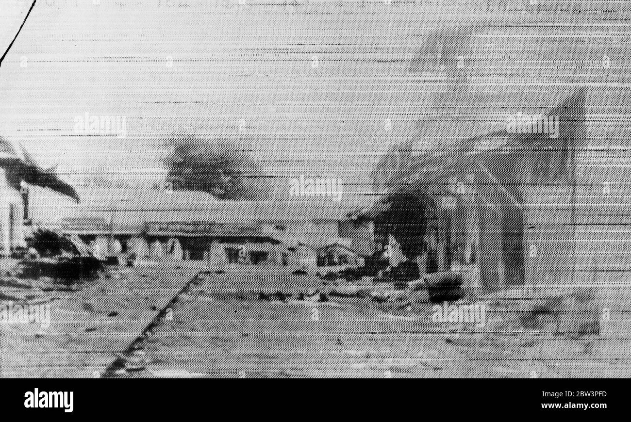 First pictures of sacked Addis Ababa , looting and burning after emperor ' s flight . This picture , transmitted from Djibuti , French Somaliland , is the first received in London of the sacked capital of Abyssinian , looted by rioting mobs after the flight of Emperor Haile Selassie to Palestine . Before the entry of the victorious Italian troops , bands of Abyssinian brigands pouring down from the hills , and even the inhabitants , joined in looting the city , fighting among themselves for the loot . Foreign nationals sought refuge in their threatened Legations and the rioters were fighting i Stock Photo