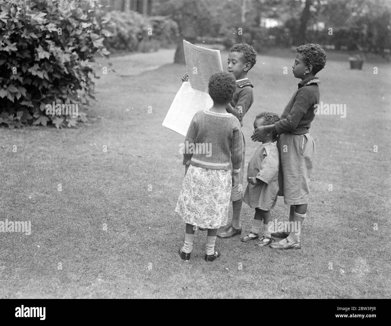 Children of Abyssinian Minister read latest news of crisis . Four children of Dr Martin , the Abyssinian Minister in London , reading the latest news of their country 's dispute with Italy in the grounds of the Abyssinian Legation . 20 July 1935 Stock Photo