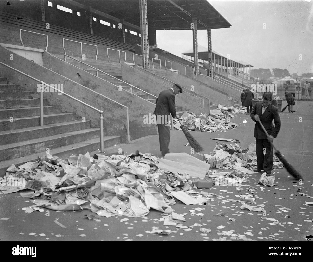 Cleaning up Epsom Downs after Derby Crowds . An army of cleaners descended on Epsom Downs to remove the litter tons of it left behind by the Derby crowds . Photo shows , cleaning up on Epsom Downs this morning ( Thursday ) . 28 May 1936 Stock Photo