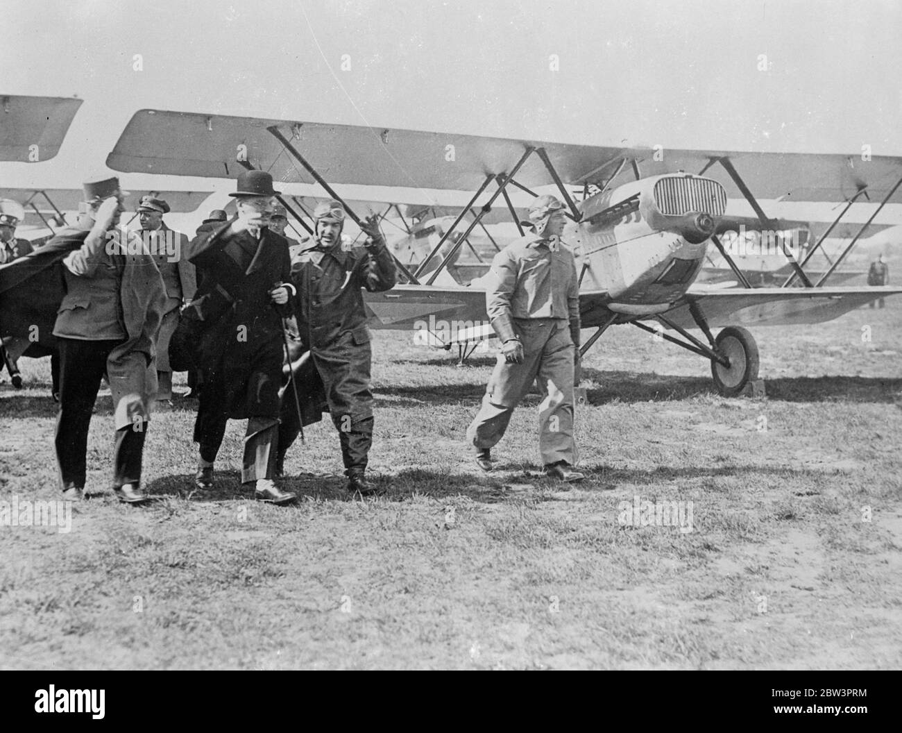 Chancellor Schuschnigg makes first inspection of Austia ' s fighting planes . Although military aeroplanes are forbidden Austria under post war treaties , Chancellor Schuschnigg made his first inspection of Austria ' s new fighting planes during the military Sping parade in Vienna . Austria recently repudiated the Treaty of St Germain , by which she was bound to an army of only 30 , 000 men by reintroducing conscription . Photo shows , Chancellor Schuschnigg saluting as he made his inspection of the fighting planes at the Vienna flying field . 20 April 1936 Stock Photo