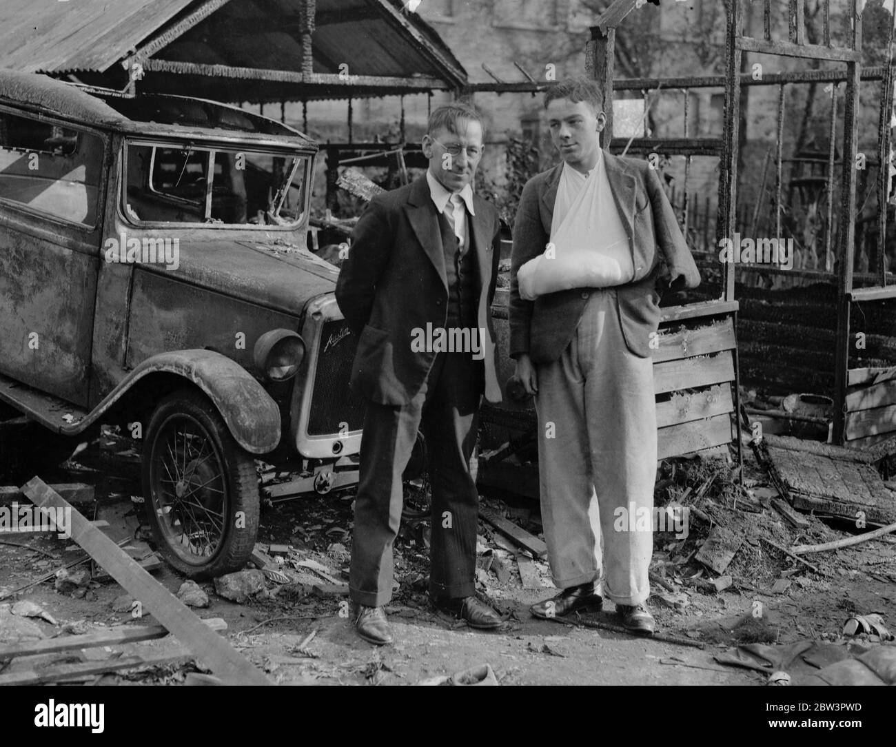 Father rescues son from blazing garage in Church Walk , Stoke Newington . Mr K G Foulds and his son Kenneth , whom he rescued , in the burned out garage . 19 October 1935 Stock Photo