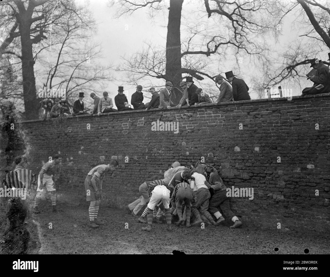 Collegues and oppidans play Eton game in mud . The annual Wall Game , the traditional struggle between Collegers and Oppdiana took place at Eton College as part of the St Andrew ' s Day celebrations . Each side worked hard to score the first goal for 26 years , but rain made play extremely difficult . Photo shows , the wall game in progress . 30 November 1935 Stock Photo