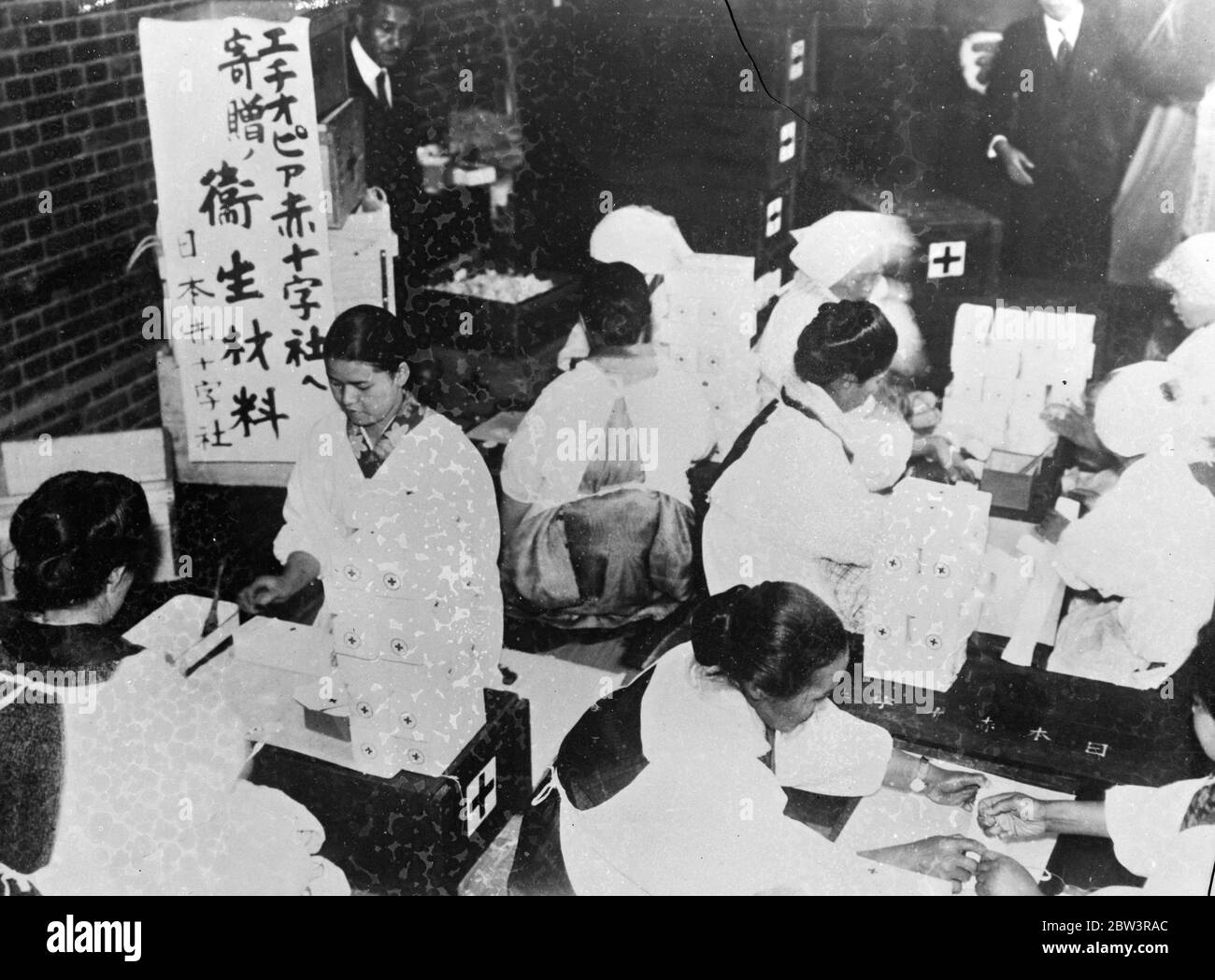 Japanese Red Cross aids in Abyssinia . The Japanese Red Cross in Tokyo are assisting in the treatment of Abyssinians wounded in the war . Large consignments of surgical supplies are being sent to the battle zone . Photo shows packing boxes of bandages for despatch to Ethopia at the Japanese headquarters in Tokyo . 1935 Stock Photo