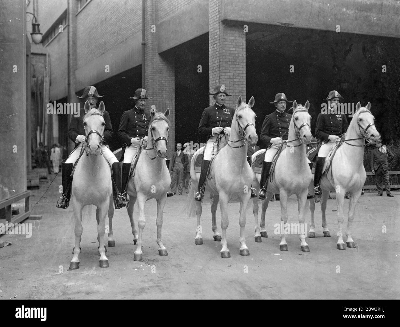 Riders from famous Vienna school rehearse at Olympia for International horse show . Riders of the historic Imperial Riding School in Vienna rehearsed the equine ballet at Olympia , London in readiness for the International Horse Show opening May 30 . Photo shows , the Austrian riders in their picturesque uniforms at Olympia . 28 May 1936 Stock Photo