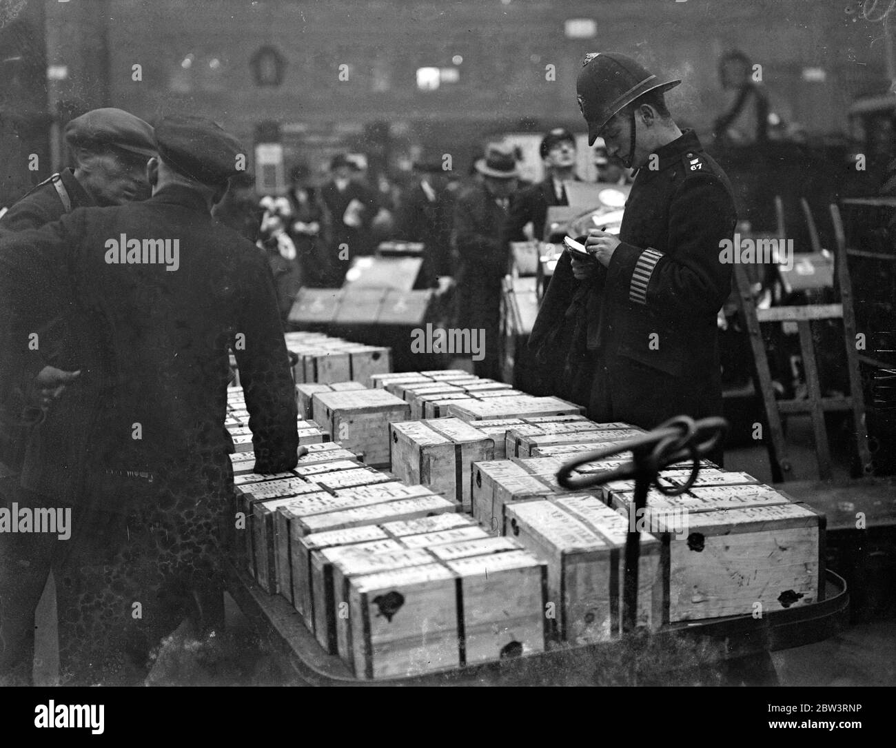 The last inspection . £1,500,000 in gold checked on railway station platform . To all appearances practically unguarded , a million and a half pounds ' worth of gold was checked on the platform at Waterloo before being loaded on the Francoais boat train for America . Photo shows , checking of the gold . 27 December 1935 Stock Photo