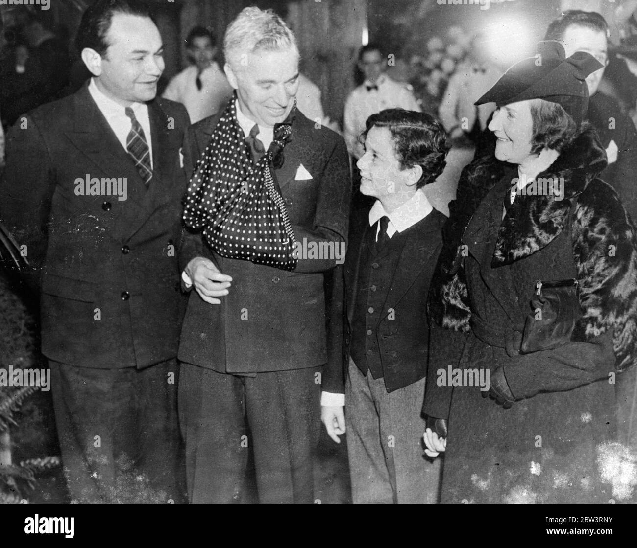 Charlie Chaplin with his arm in a sling . Freddie Bartholomew at show to raise money for Will Rogers Memorial . Left to right - Edward G Robinson , Charlie Chaplin ( with arm in sling ) , Freddie Bartholomew , and Freddie 's aunt at the show . 12 December 1935 Stock Photo