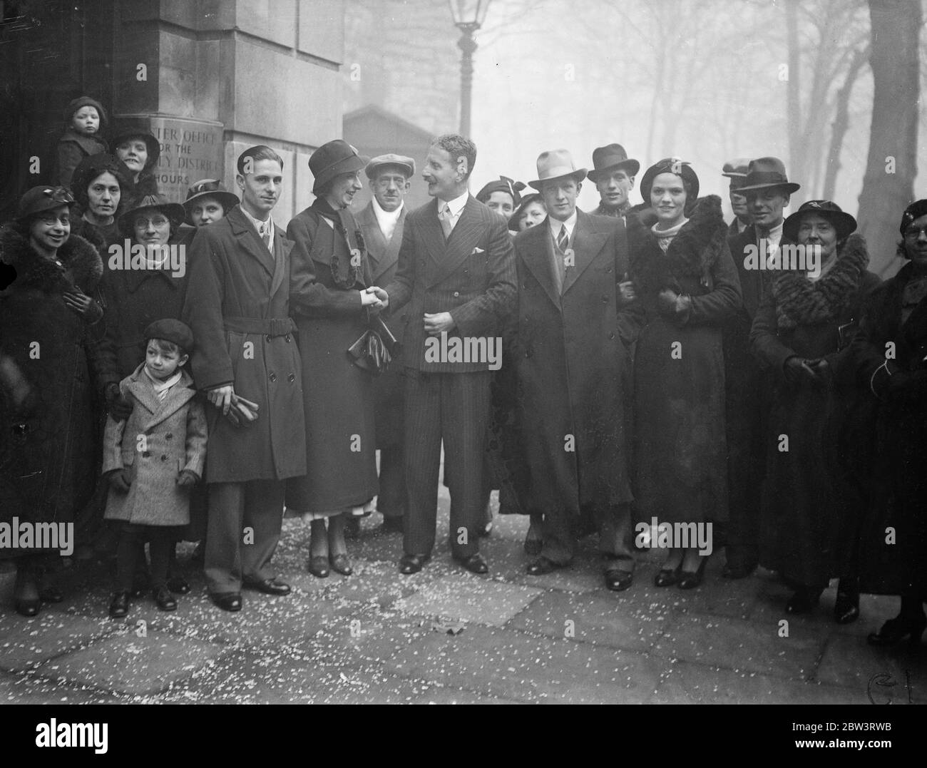 Christmas marriage records broken at Hackney as registrar performs 40 ceremonies in one day . All christmas records are being broken today ( Saturday ) at the Hackney Town Hall register office , where Mr A W Brewer , superintendent registrar , is having to perform 40 marriage ceremonies . Mr Brewer , is marrying the couples himself , and had to rise at 7 am . He has never married so many couples in one day at Christmas time before . Photo shows , Mr A W Brewer ( centre , with moustache ) congratulating some of the couples . 21 December 1935 Stock Photo