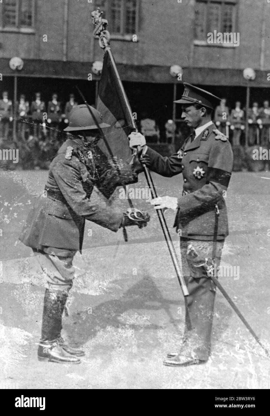 King Leopold Presents New Standard to Anti - Aircraft Regiment . King Leopold of the Belgians presented a new standard to the 2nd Regiment of Defence against Aircraft at the Saint - Anne Barracks , Laeken near Brussels . Photo shows : King Leopold presenting the standard . 24 Jul 1936 Stock Photo