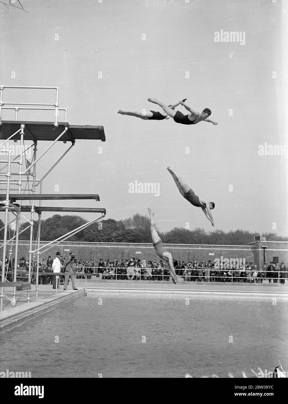 First plunge into new Victoria Park swimming pool . Mr Herbert Morrison , MP , Leader of the London County Council , opened the new open air swimming bath in Victoria Park . Photo shows , members of Highgate Diving club in mid air as they inaugurated the new pool . 16 May 1936 Stock Photo