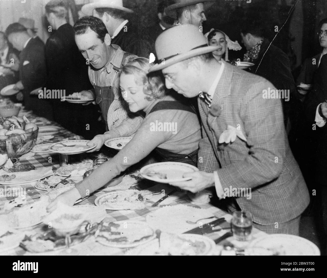 Barn dance at Hollywood given by Grace Bradley . Left to right - Harold Lloyd , Mrs Lloyd and Harry Duskin raid the buffet . 20 December 1935 Stock Photo