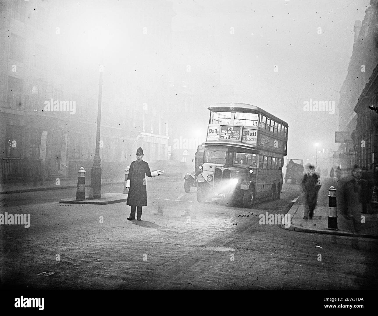 London 's first  Pea Souper  . A bus trying to penetrate the fog with its yellow lamp at Blackfriars . 7 December 1935 Stock Photo