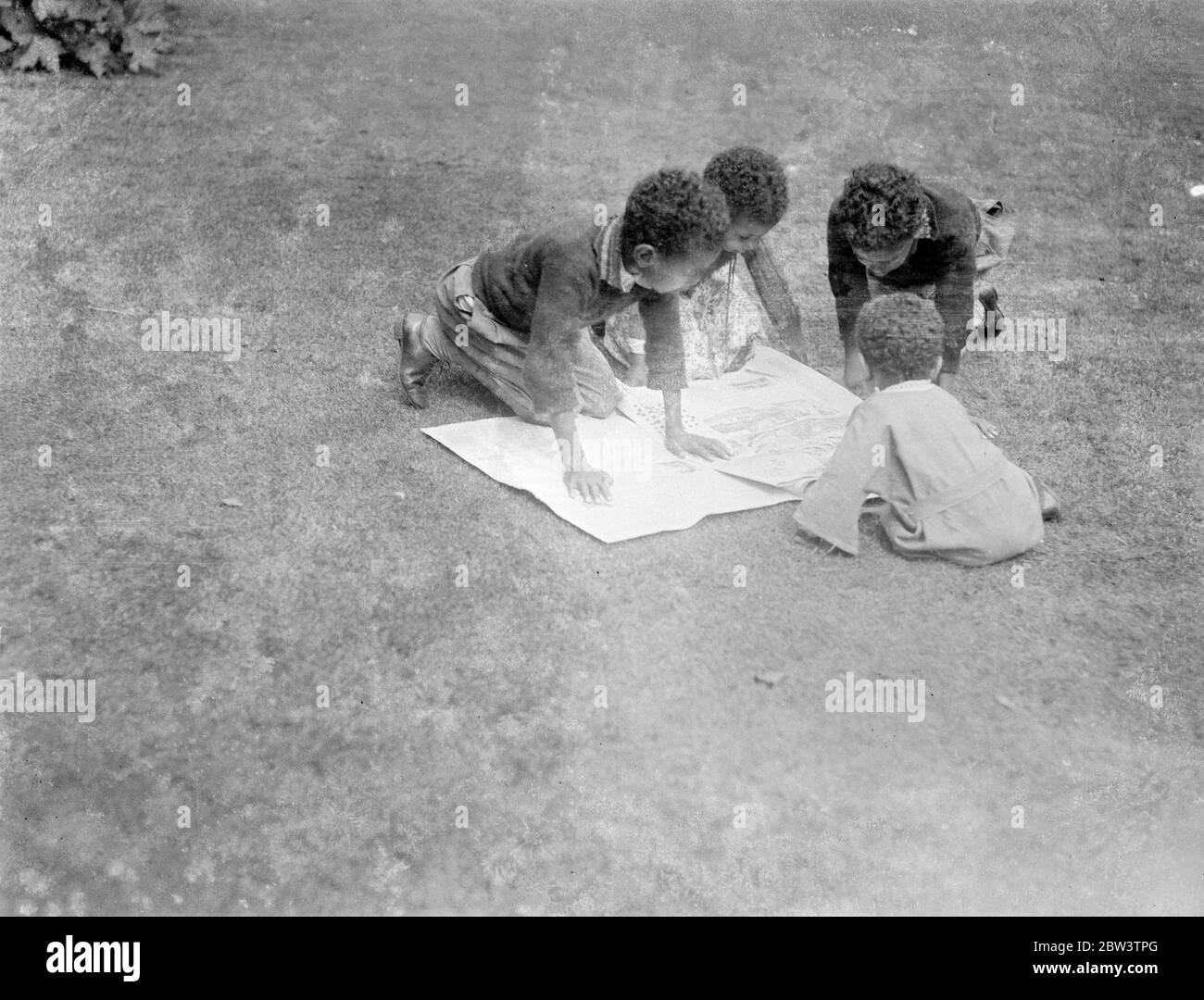 Children of Abyssinian Minister read latest news of crisis . Four children of Dr Martin , the Abyssinian Minister in London , reading the latest news of their country 's dispute with Italy in the grounds of the Abyssinian Legation . 20 July 1935 Stock Photo