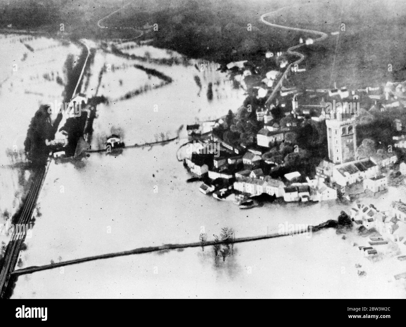 France underwater picture from the air . The French town of Nantes is menaced by the worst floods known for many years . The waters are still rising desoite ceaseless efforts to avert complete disaster . The terror stricken population threaten to panic though police and relief workers are attempting to maintain calm . Photo shows , a view from the air of flooded Nantes . In the picture can be seen the Tower of Oudon ( right ) and teh partly submerged railway line . 8 January 1936 . Stock Photo