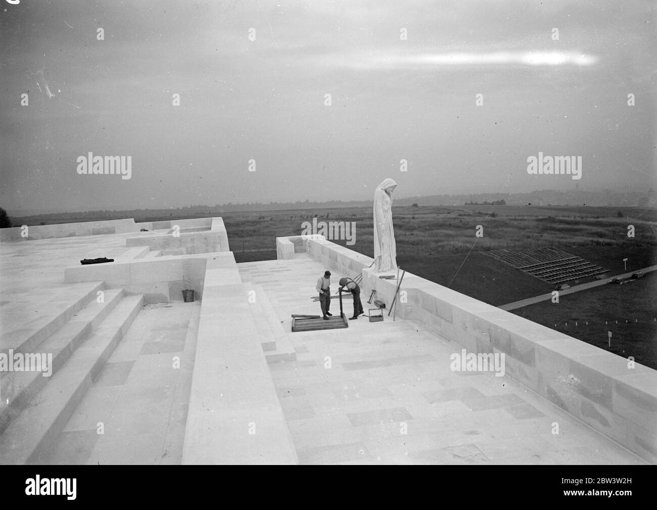 Last-minute preparations at Vimy Memorial for unveiling by the King . Workmen are rushing to prepare the Vimy Ridge Memorial, greatest of all was shrines and Canada's tribute to her war dead, at Arras , France, in readiness for the unveiling by the King next Sunday (26th of July). . The Memorial , which took ten years to build , contains the names of 11 , 700 men , many of whom fell on the battlefields over which the 138 feet shrine towers . The work of Mr Walter Allward , the Canadian sculptor , the 30 , 000 ton memorial stands on 240 acres of ground presented to Canada by the French Governme Stock Photo