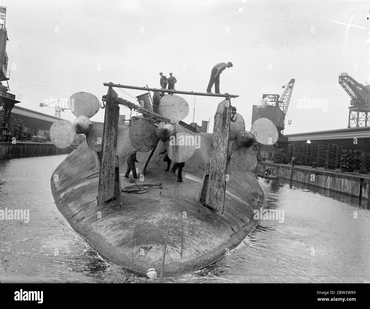 Konig Albert , one time pride of Germany Navy , being broken up at Rosyth . Work has started in Rosyth Dockyard , Scotland , on the breaking up of the 20 , 000 ton ex German battleship Konig Albert , which was salvaged from Scapa flow where she was scuttled with other German vessels after the war . The hulk , which is lying upside down , is being shored up so that the water can be run out of the dock . Photo shows , workmen busy among the massive propellers of the Konig Albert as they dismantle the gear . 25 May 1936 Stock Photo