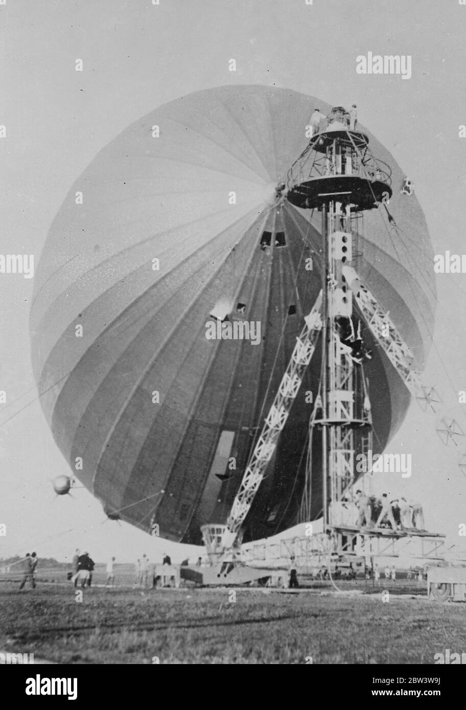 ' Hindenburg ' Germany ' s giant airship , at Rio De Janeiro . These pictures just received in London by air , show the ' Hindenburg ' , Germany ' s gigantic new airship , at the Santa Cruz aerodrome Rio de Janeiro agter her maiden voyage to South America from Friedrichshaven . A special mast and hangar had been built at the aerodrome to accommadate the new airship . Photo shows , the Hindenburg being fastened to her mooring mast at Rio de Janeiro . 13 April 1936 Stock Photo